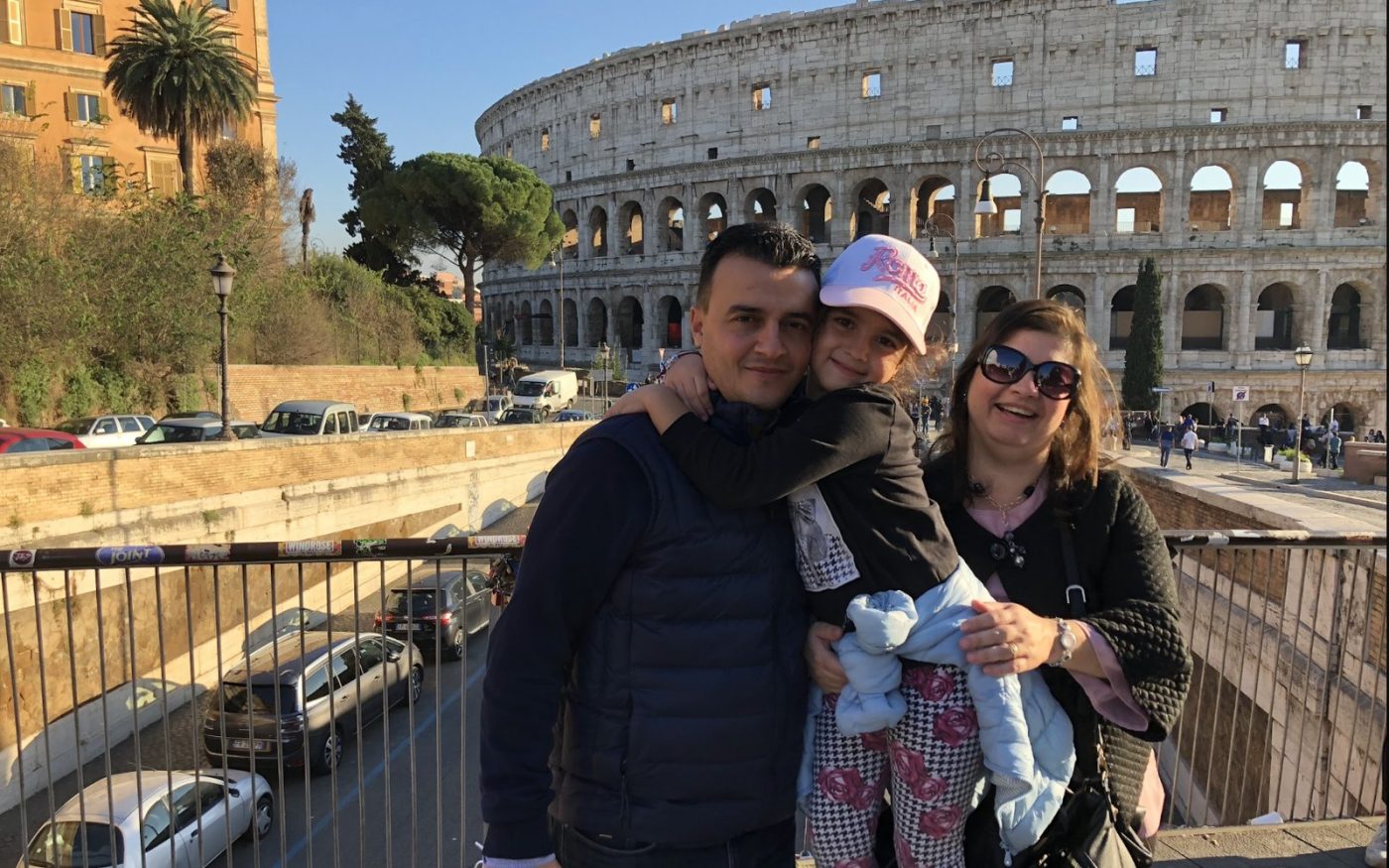 A family with a child by the walls of the Colosseum
