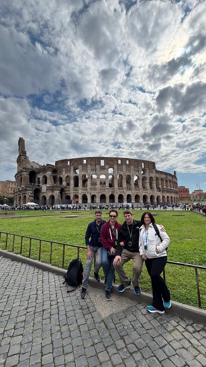 A family with children on a bench opposite the Colosseum