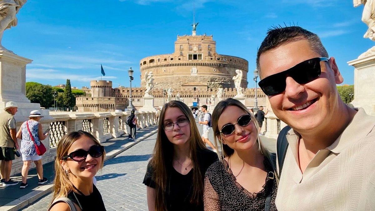 A family on Ponte Sant’Angelo, Castel Sant’Angelo behind them