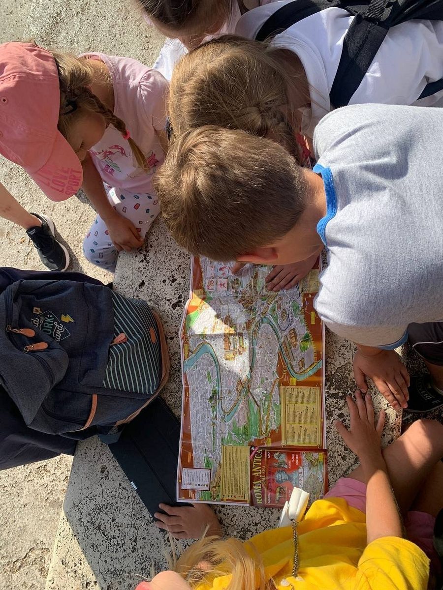 Children bending over the quest map