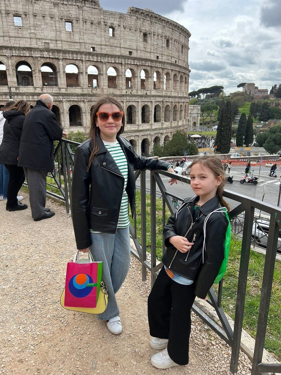 Mother and daughter at the Colosseum point towards the arena