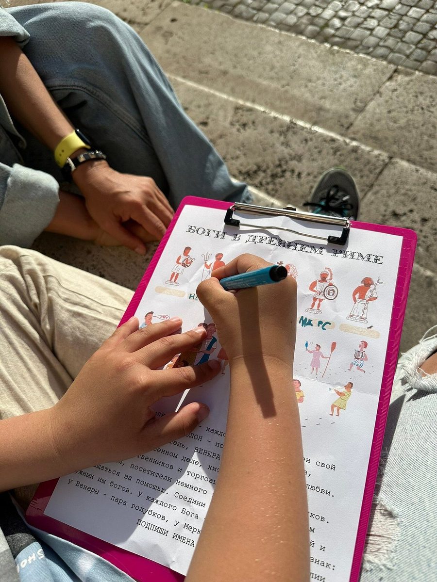 A child writes the answers on the quest form on a clipboard