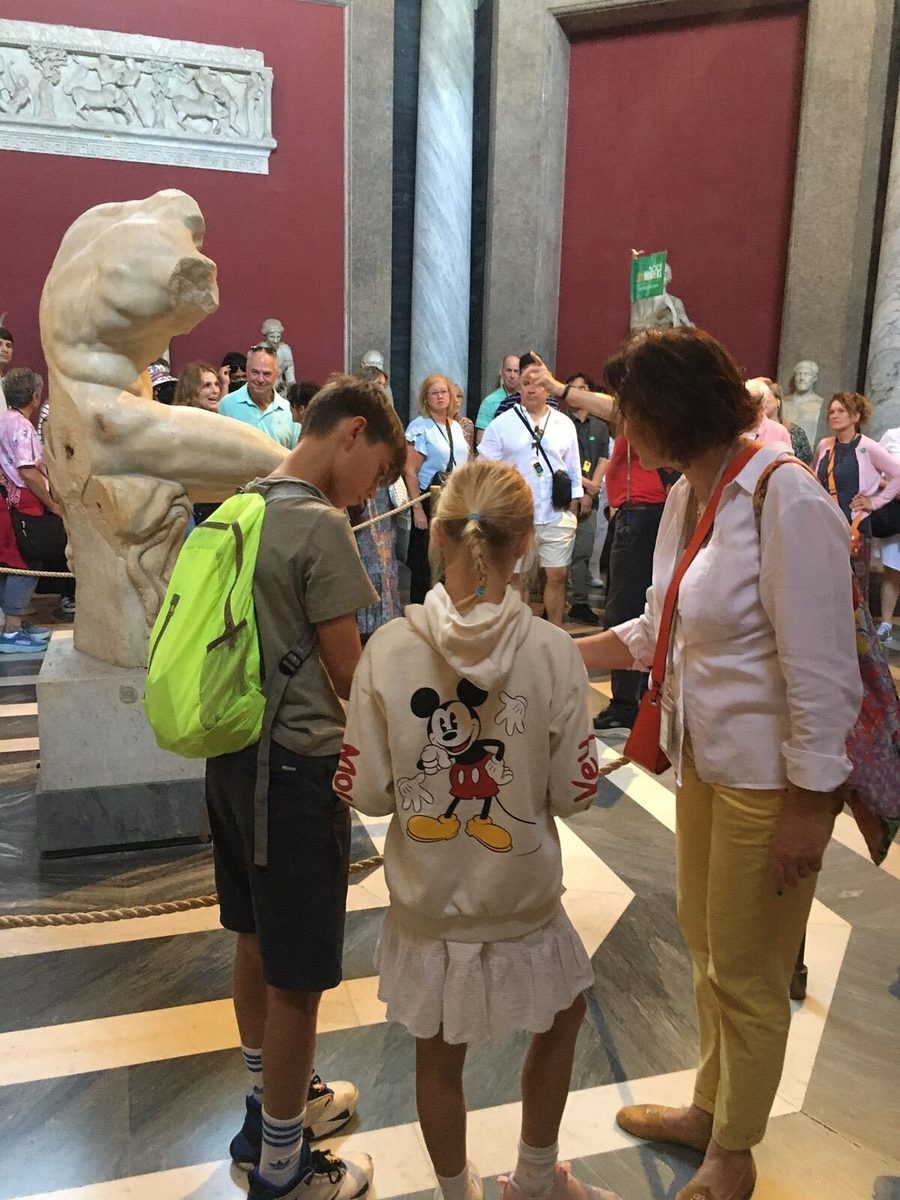 Teenagers by an ancient statue in the Vatican Museums