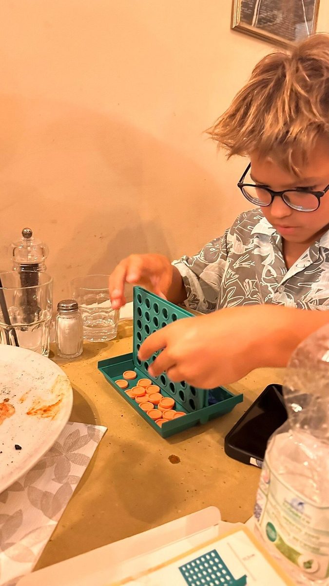 A child at a board game in a cafe